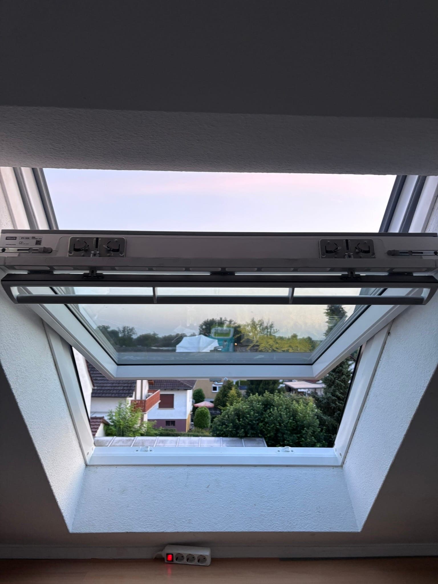 Geöffnetes Dachfenster mit Blick über die Dächer