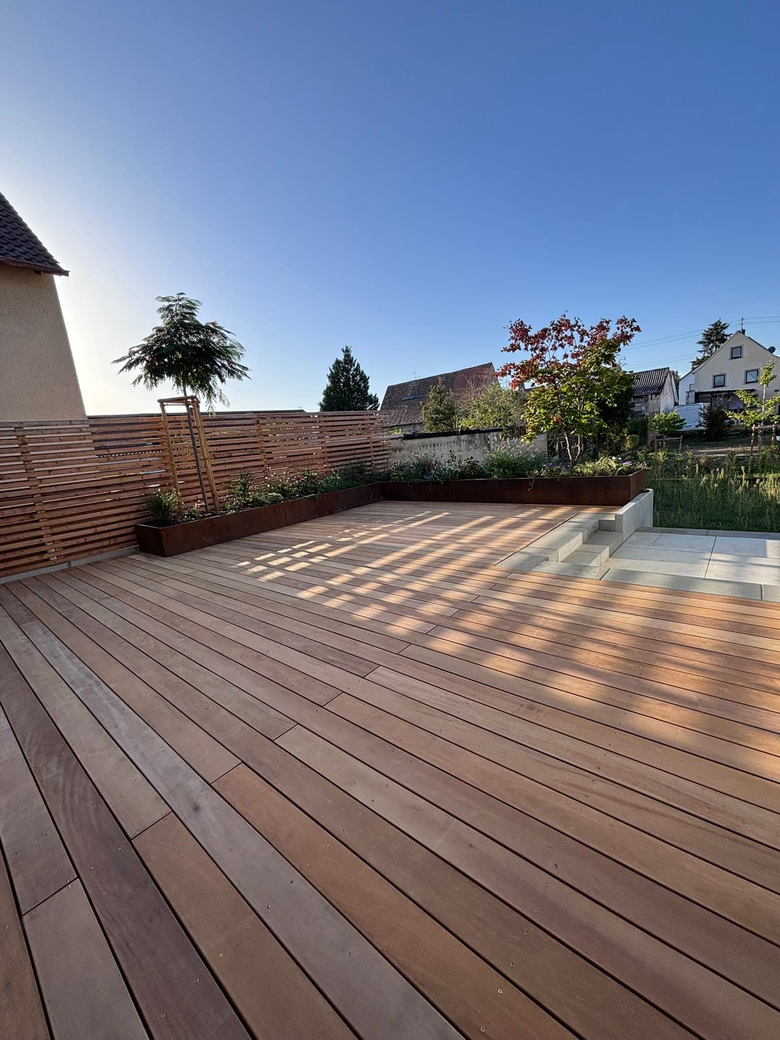 Holzterrasse mit Sichtschutzzaun im Hintergrund
